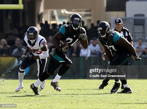 Yeldon of the Jacksonville Jaguars runs for yardage as teammate Patrick Omameh looks turnover block and Eddie Pleasant of the Houston Texans pursues...