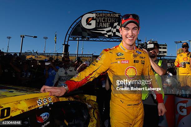 Joey Logano, driver of the Shell Pennzoil Ford, poses with the winner's decal on his car in Victory Lane after winning the NASCAR Sprint Cup Series...