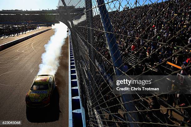 Joey Logano, driver of the Shell Pennzoil Ford, celebrates with a burnout after winning the NASCAR Sprint Cup Series Can-Am 500 at Phoenix...