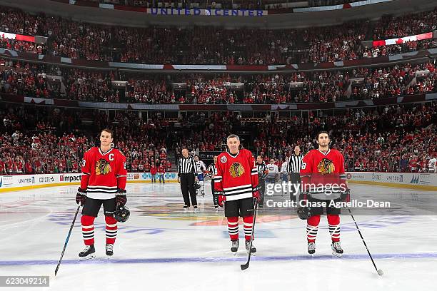 Denis Savard, hockey Hall of Famer, stands in between Ryan Hartman and Jonathan Toews of the Chicago Blackhawks while being honored during the...