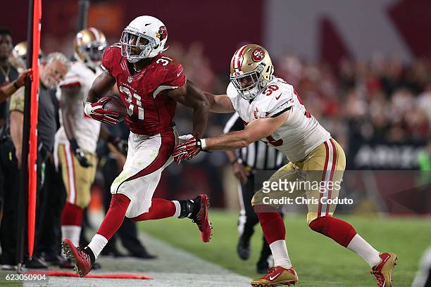 Running back David Johnson of the Arizona Cardinals is pushed out of bounds by inside linebacker Nick Bellore of the San Francisco 49ers during the...