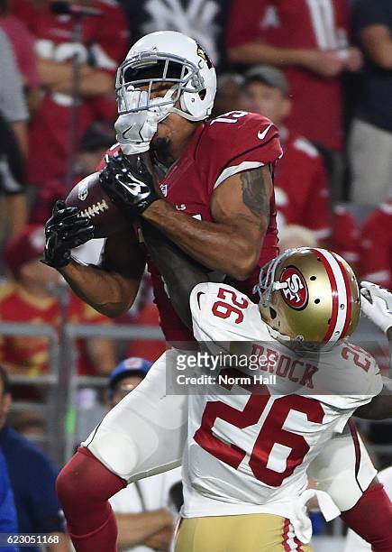 Michael Floyd of the Arizona Cardinals attempts to make a catch as Tramaine Brock of the San Francisco 49ers gets his hand get caught in Floyds...