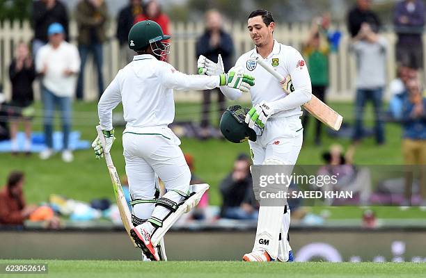 South Africa's batsman Temba Bavuma greets Quinton de Kock for his century on the third day's play of the second Test cricket match between Australia...