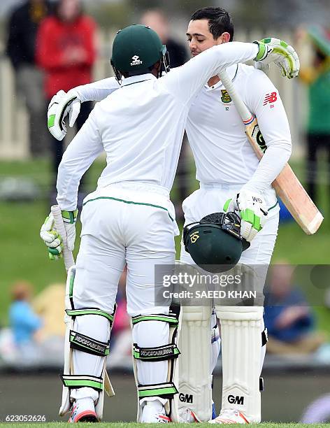 South Africa's batsman Temba Bavuma greets Quinton de Kock for his century on the third day's play of the second Test cricket match between Australia...