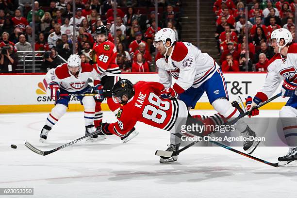 Patrick Kane of the Chicago Blackhawks shoots the puck against Max Pacioretty and Jeff Petry of the Montreal Canadiens, resulting in a goal in the...