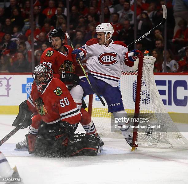 Andrew Shaw of the Montreal Canadiens is shoved in the goal by Ryan Hartman of the Chicago Blackhawks behind Corey Crawford at the United Center on...