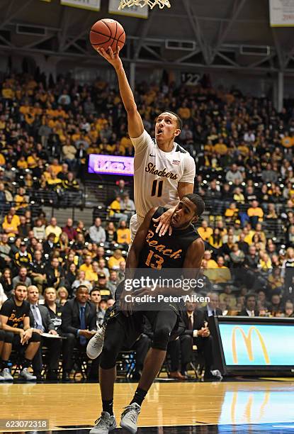 Guard Landry Shamet of the Wichita State Shockers drives to the basket over guard Barry Ogalue of the Long Beach State 49ers during the first half on...