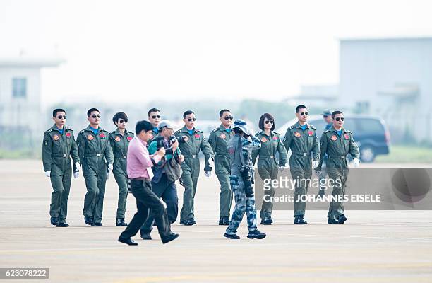 This picture taken on November 11, 2014 shows Chinese female J-10 fighter pilot Yu Xu walking to the fighter planes ready to perform at the Airshow...