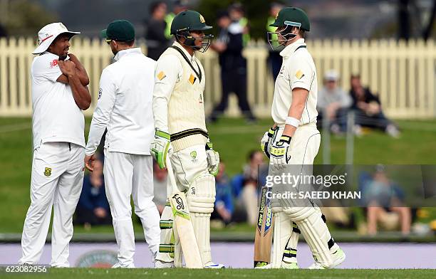 Australia's batsman Usman Khawaja talks to captain Steven Smith on the third day's play of the second Test cricket match between Australia and South...