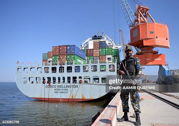 Pakistani Naval personnel stands guard beside a ship carrying containers during the opening of a trade project in Gwadar port, some 700 kms west of...