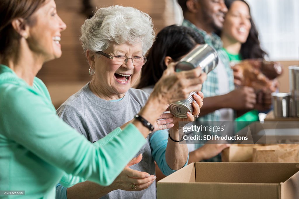 Amigas felices como voluntarias en el banco de alimentos de caridad