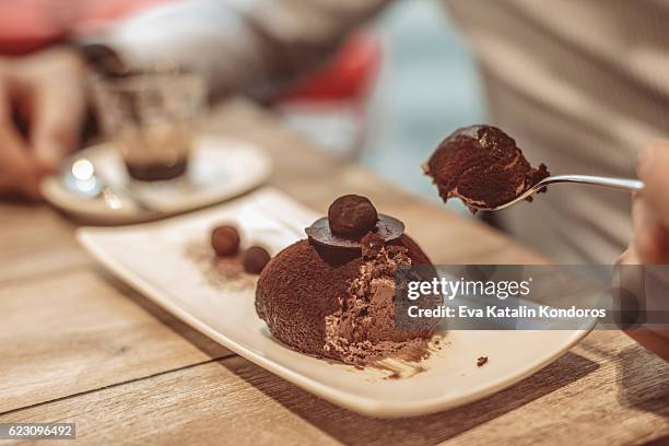 young man eating chocolate cake - chocolate pudding imagens e fotografias de stock