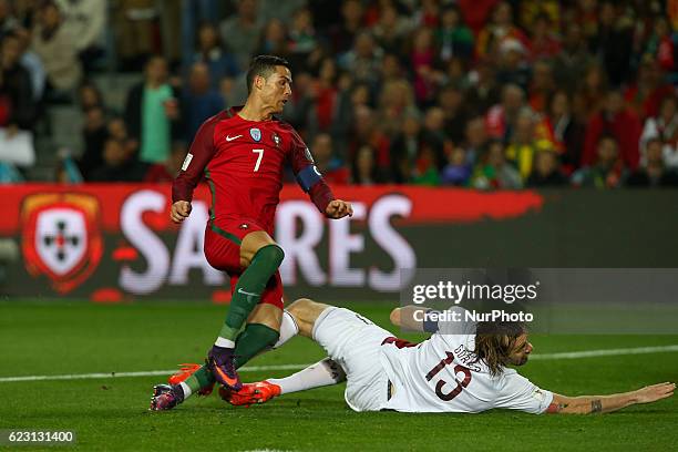 Portugals forward Cristiano Ronaldo and Latvia's defender Kaspars Gorses from Latvia during the 2018 FIFA World Cup Qualifiers matches between...