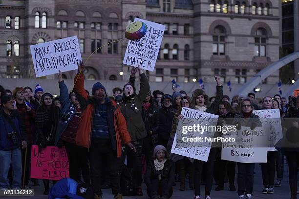 Group of Trump protesters, holding various banners, peacefully gather on 13 November in Toronto, Canada came to the streets to show solidarity with...