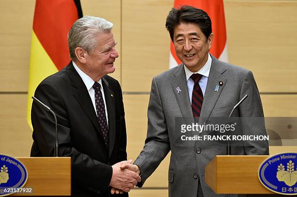 German President Joachim Gauck shakes hands with Japan's Prime Minister Shinzo Abe after a joint press conference at Abe's official residence in...