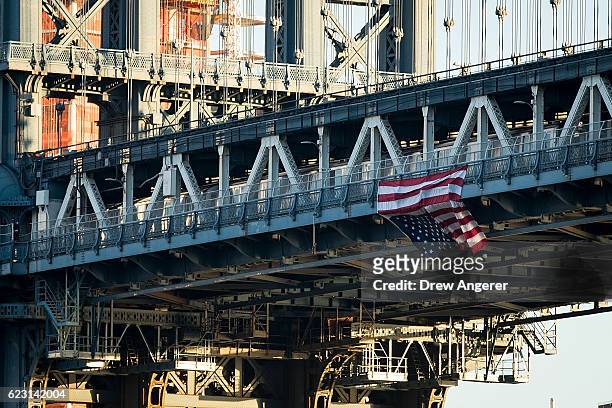 Hung by anti-Donald Trump protestors, an upside down American flag hangs from the side of the Manhattan Bridge on November 14, 2016 in New York City....