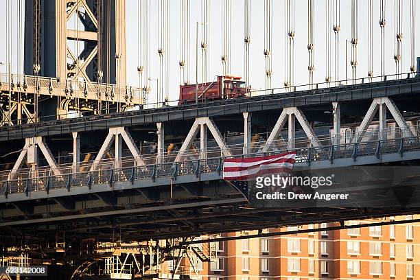 Hung by anti-Donald Trump protestors, an upside down American flag hangs from the side of the Manhattan Bridge on November 14, 2016 in New York City....