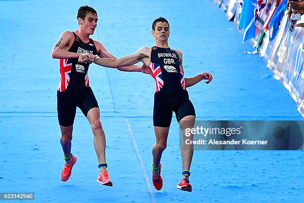 Alistar Brownlee of Great Britain helps his brother Jonathan Brownlee of Great Britain to cross the finished line as Jonathan collapsed of...