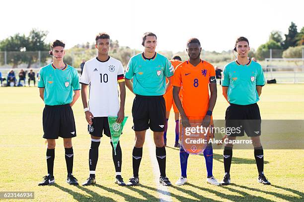 Timothy Tillman of Germany and Leandro Fernandes of Netherlands pose with the referees before during the U18 international friendly match between...