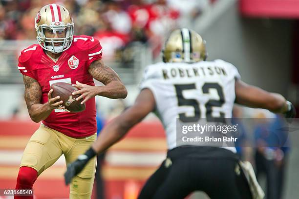 Quarterback Colin Kaepernick of the San Francisco 49ers looks for a receiver against linebacker Craig Robertson of the New Orleans Saints in the...