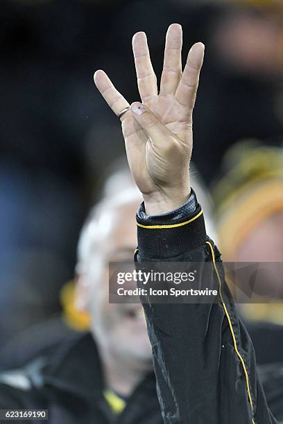 Fan holds up his hand to indicate the start of the fourth quarter during a Big Ten Conference football game between the Michigan Wolverines and the...