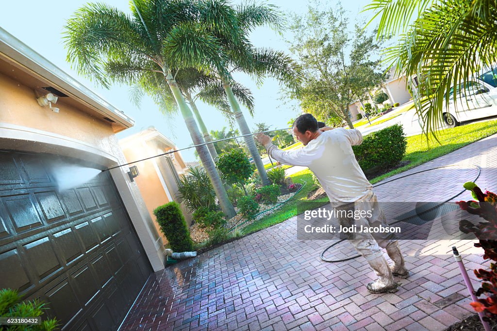Series:Hispanic Male painter power washing an upscale home