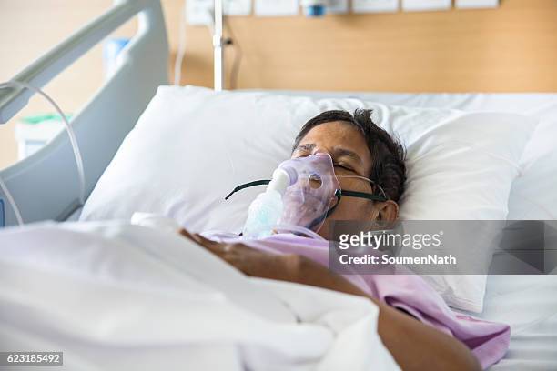 vieille femme avec masque de ventilateur sur le lit d’hôpital - ventilator photos et images de collection