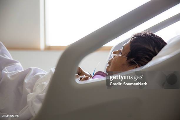 old woman on hospital bed, oxygen tubes in her nose - soumen nath stock pictures, royalty-free photos & images