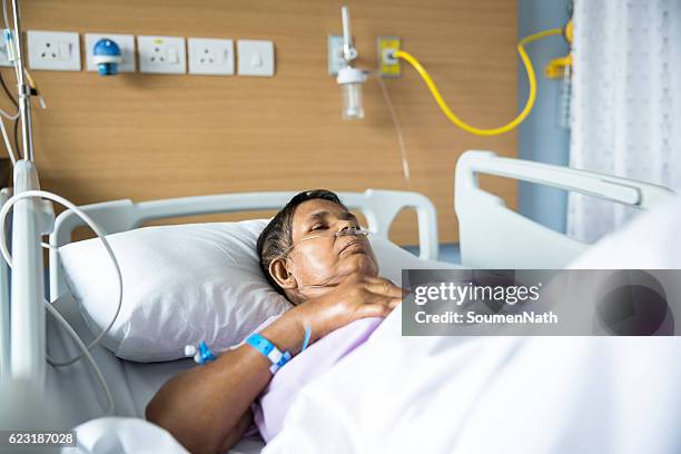 old woman on hospital bed, oxygen tubes in her nose - soumen nath stock pictures, royalty-free photos & images