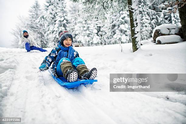 madre e hijo jugando en la nieve - sled sledding fotografías e imágenes de stock