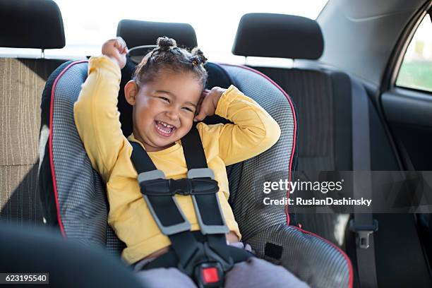 toddler girl sitting on safety car chair. - baby car seat stock pictures, royalty-free photos & images