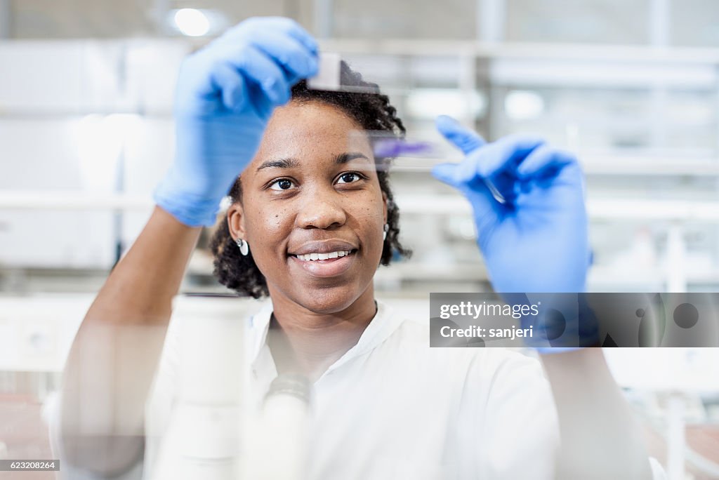 Científico mirando un portaobjetos de microscopio