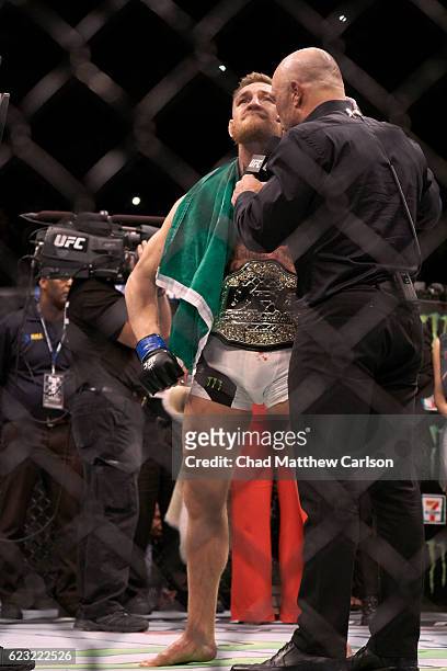 Conor McGregor victorious wearing belt and Irish flag after winning Men's Lightweight fight vs Eddie Alvarez at Madison Square Garden. New York, NY...