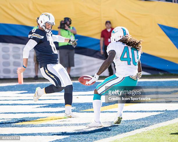 San Diego Chargers Punter Drew Kaser punts from the end-zone under pressure from Miami Dolphins Cornerback Lafayette Pitts during the NFL football...
