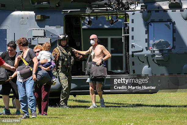 Military staff help assist tourists trapped by the Kaikoura earthquakes as they arrive by military helicopters at Woodend School grounds on November...