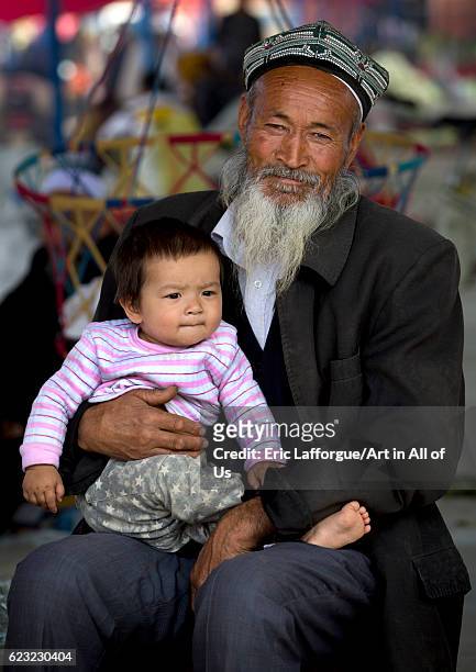 Old Uyghur man and baby, Serik Buya market, Yarkand, Xinjiang Uyghur Autonomous Region, China on September 20, 2012 in Yarkand, China.