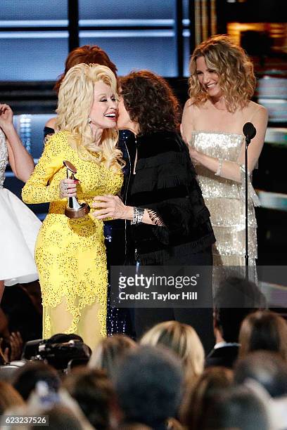 Dolly Parton accepts an award from Lily Tomlin onstage during the 50th annual CMA Awards at the Bridgestone Arena on November 2, 2016 in Nashville,...