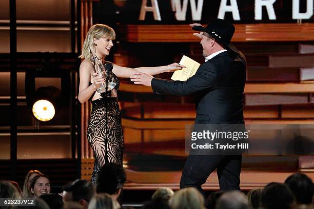 Taylor Swift presents an award to Garth Brooks onstage during the 50th annual CMA Awards at the Bridgestone Arena on November 2, 2016 in Nashville,...