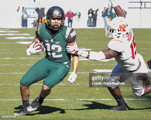 Wide receiver R.J. Shelton of the Michigan State Spartans runs up field with the football and avoids a tackle from linebacker Trevor Morris of the...