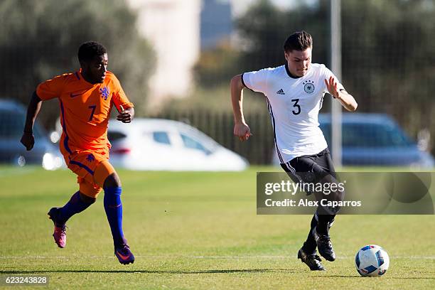 Niklas Kolle of Germany conducts the ball past Che Nunnely of Netherlands during the U18 international friendly match between Netherlands and Germany...
