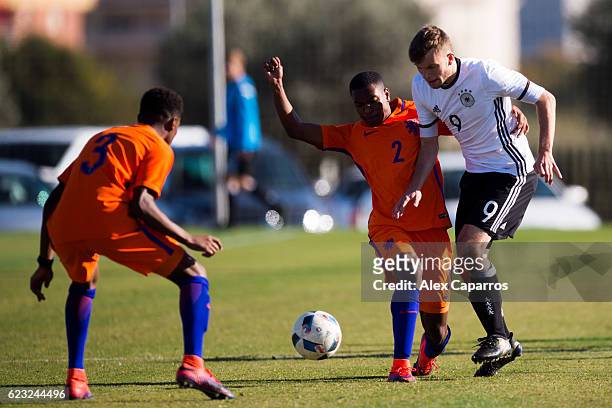 Manuel Wintzheimer of Germany competes for the ball with Navajo Bakboord and Nathanangelo Markelo of Netherlands during the U18 international...