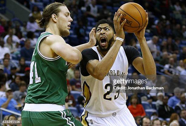 Anthony Davis of the New Orleans Pelicans drives against Kelly Olynyk of the Boston Celtics during the second half of a game at the Smoothie King...