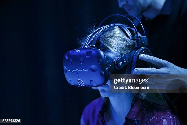 Attendees wear HTC Corp. Vive 3D virtual reality headsets before the Jaguar Land Rover Automotive PLC I-Pace Electric Concept luxury sport utility...