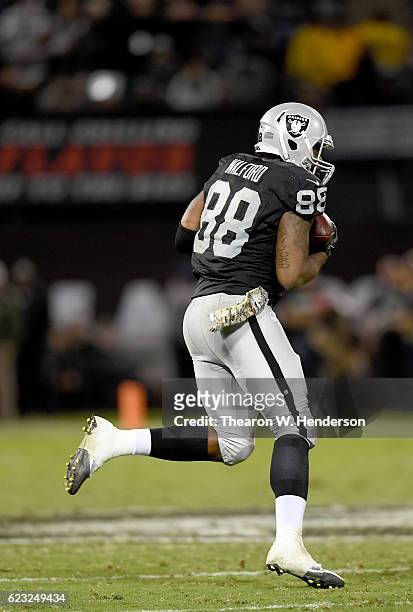 Clive Walford of the Oakland Raiders runs with the ball after catching a pass against the Denver Broncos in the fourth quarter of an NFL football...