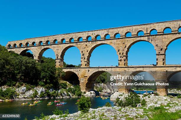 the roman bridge pont du gard and the gardon river, gard, france - pont du gard aqueduct stock pictures, royalty-free photos & images