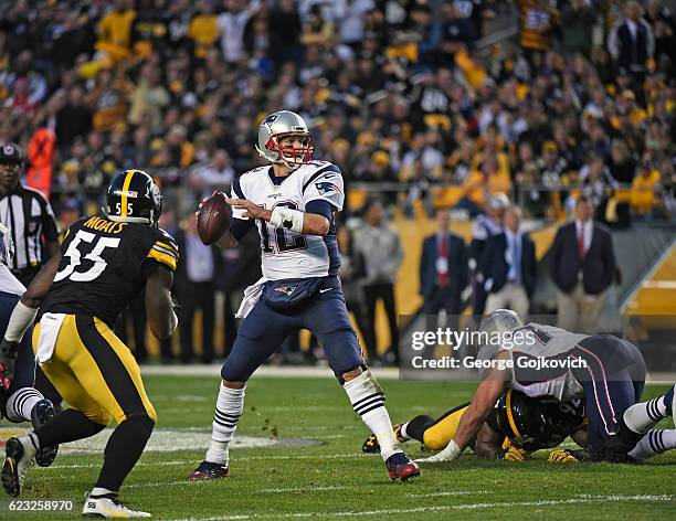 Quarterback Tom Brady of the New England Patriots passes as he is pursued by linebacker Arthur Moats of the Pittsburgh Steelers during a game at...