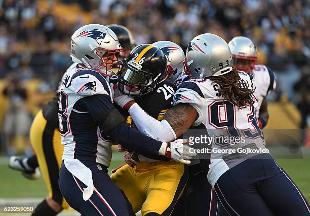 Linebacker Shea McClellin and defensive lineman Jabaal Sheard of the New England Patriots tackle running back Le"Veon Bell of the Pittsburgh Steelers...