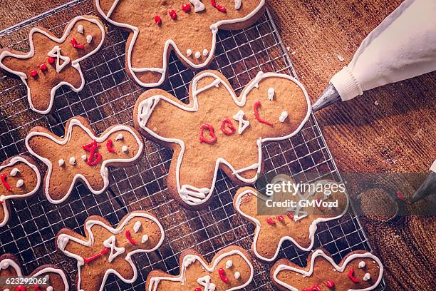 decorating christmas cookies with icing - gingerbread men stockfoto's en -beelden