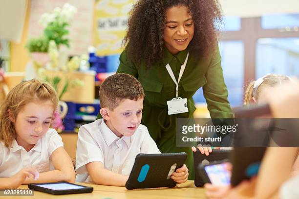 teacher with digital ready students - school uniform stock pictures, royalty-free photos & images