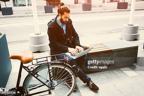 young businessman using digital tablet outdoors. - bike ipad stock pictures, royalty-free photos & images